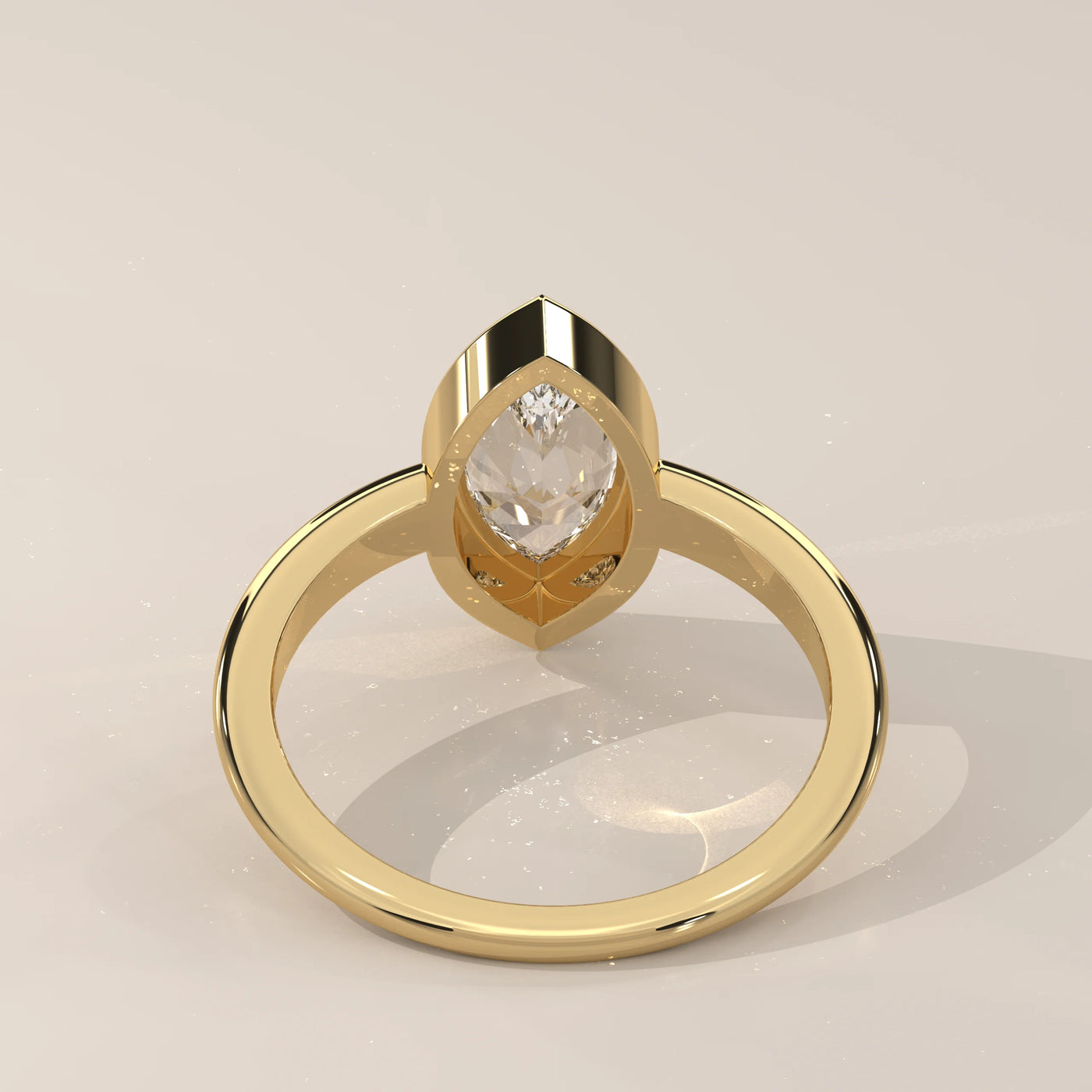 Yellow gold ring with a bezel-set marquise-cut diamond.