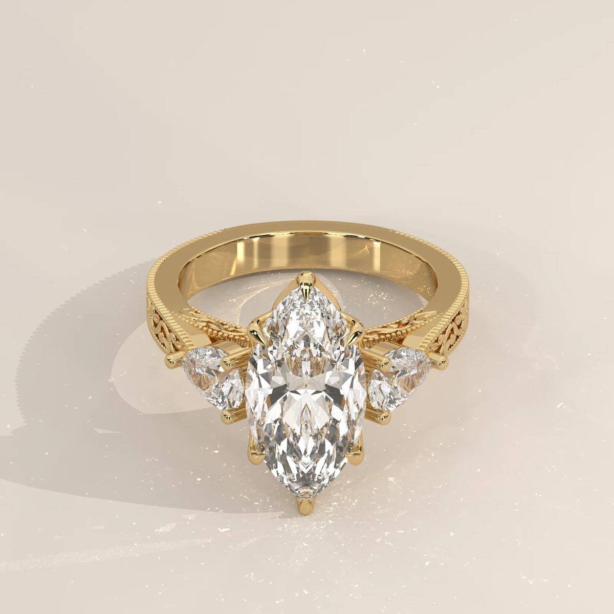 Three-quarter view: Marquise Diamond Three Stone Ring with Pear Side Stones and Vintage Engraved Band in 14K Yellow Gold – Lab Grown – Driona Jewels