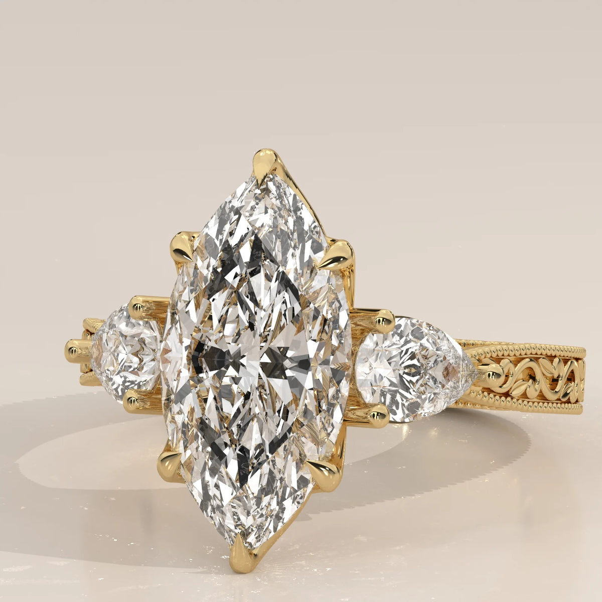 Top close-up: Marquise Diamond Three Stone Ring with Pear Side Stones and Vintage Engraved Band in 14K Yellow Gold – Lab Grown – Driona Jewels