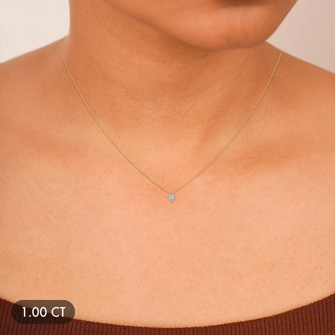A delicate gold necklace featuring a small heart-shaped diamond pendant.