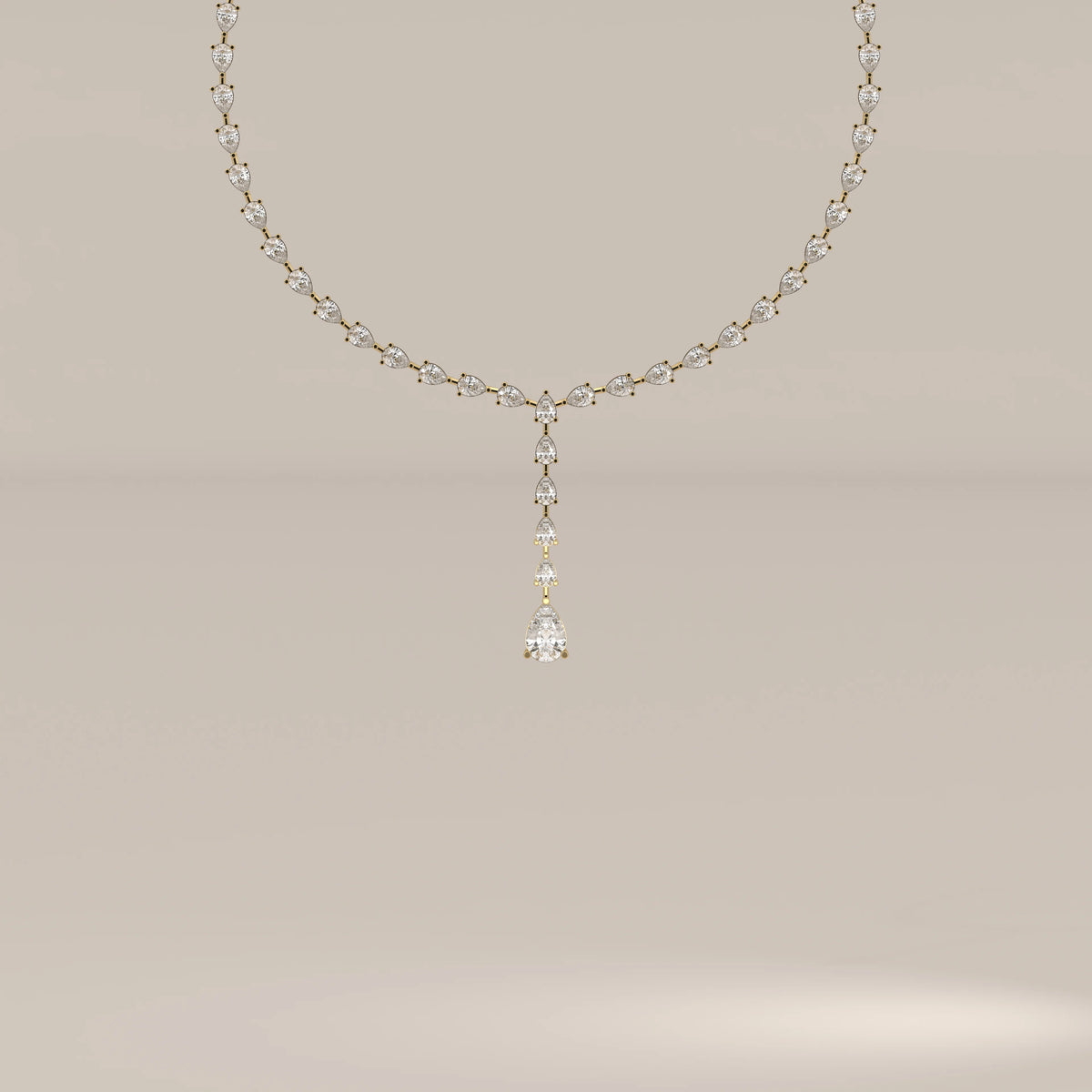 A pear shape lab grown diamond drop necklace in yellow gold, shown from the front.