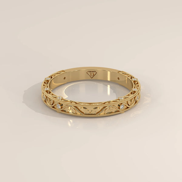 Ornate Filigree Engraved Band with Bezel Set Diamonds in yellow gold, shown at an angle.