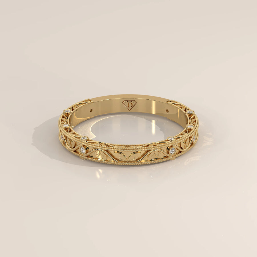 Ornate Filigree Engraved Band with Bezel Set Diamonds in yellow gold, shown at an angle.