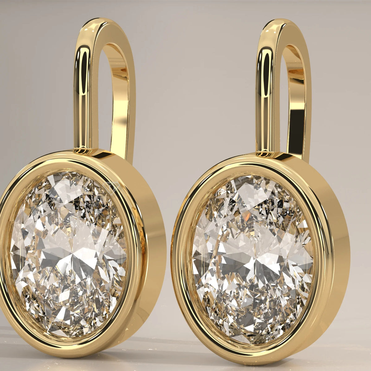 Oval Bezel Set Lab Grown Diamond Drop Earrings on a Gold Hook in yellow gold, front view on a plain background.