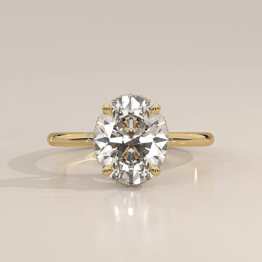 Oval cut diamond engagement ring with a paved band in yellow gold.
