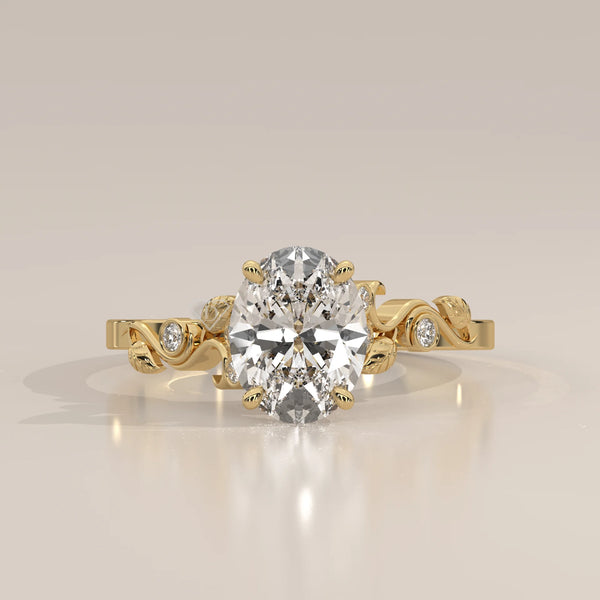 Gold ring with an oval-shaped diamond and leaf-like accents.