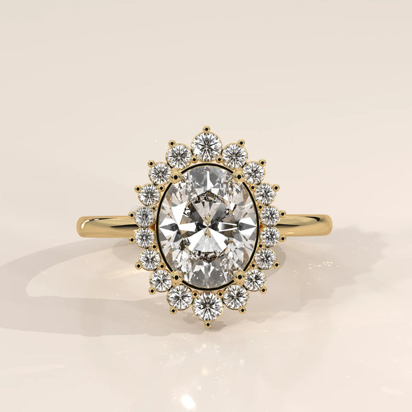 Oval diamond engagement ring with a halo of smaller diamonds, set in 14k gold.