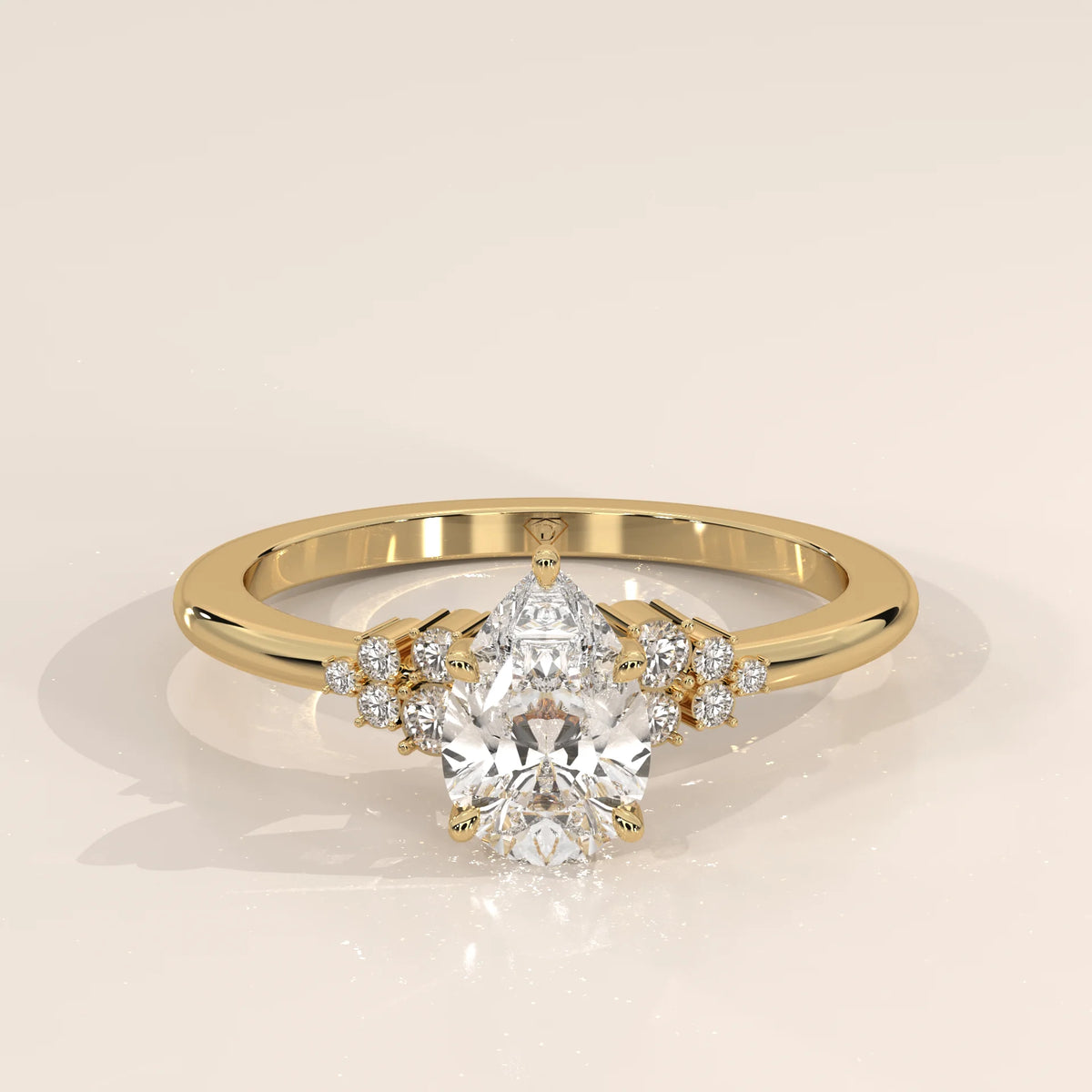 A yellow gold ring with a pear-cut diamond and smaller accent stones.