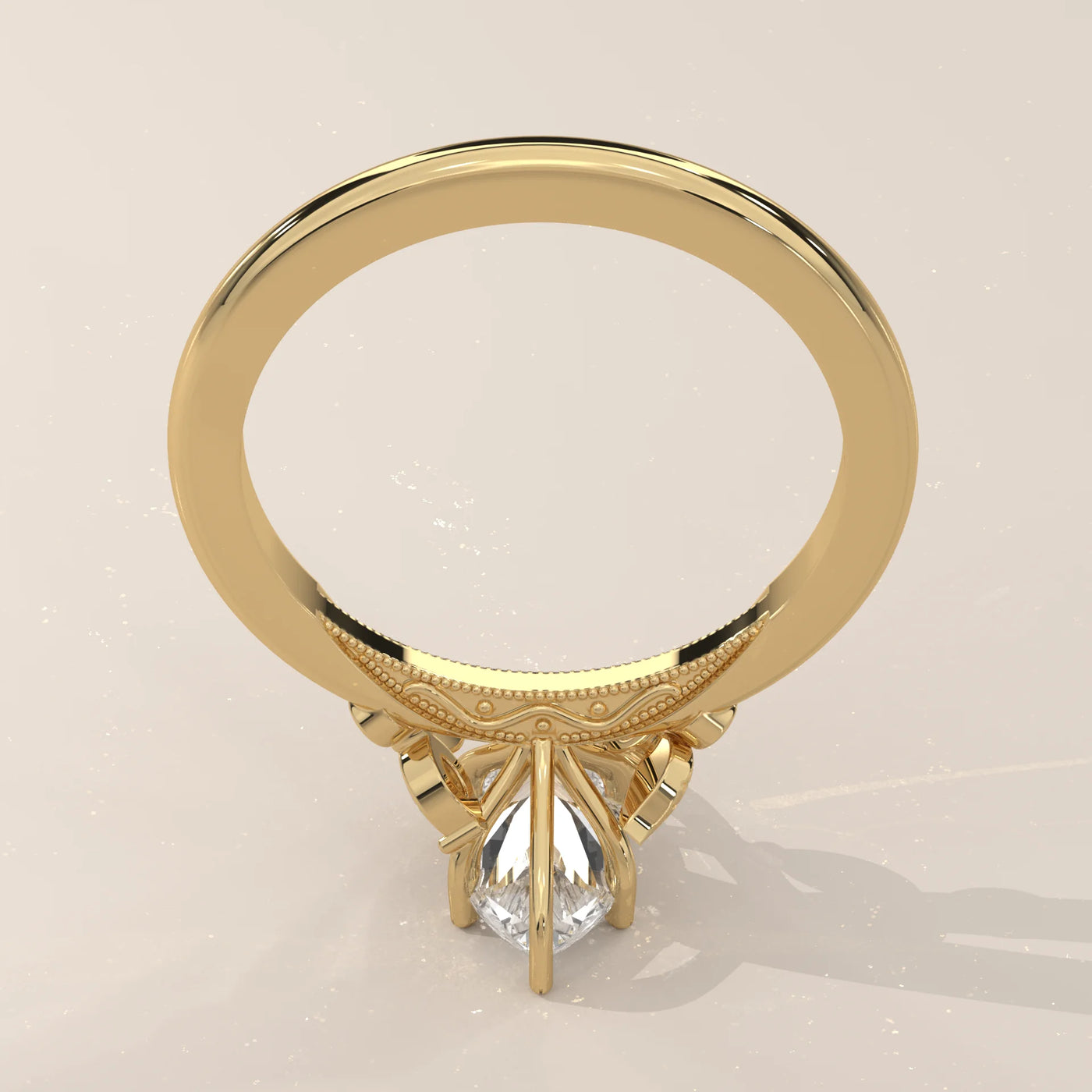Gold ring with a pear-cut diamond and intricate detailing.
