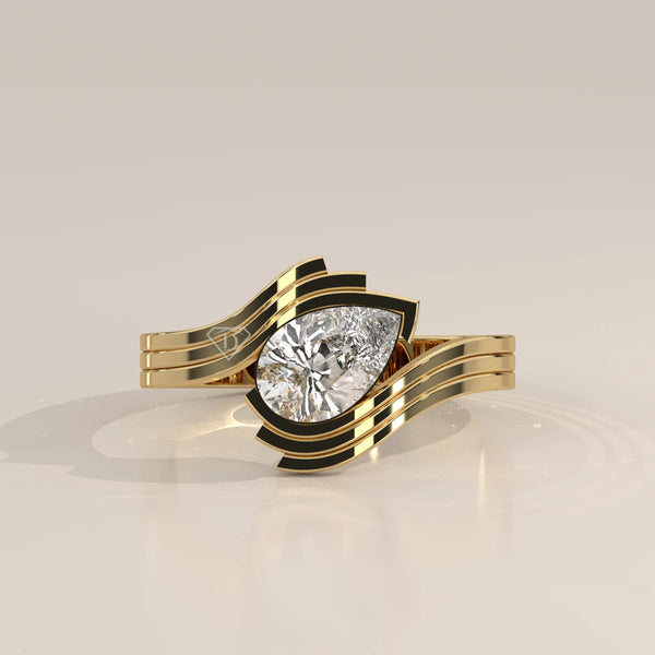 A stunning yellow gold ring with a pear-cut diamond and black accents.