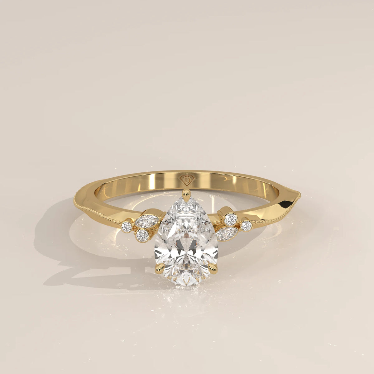 Elegant pear-cut diamond engagement ring in yellow gold with side stone accents.