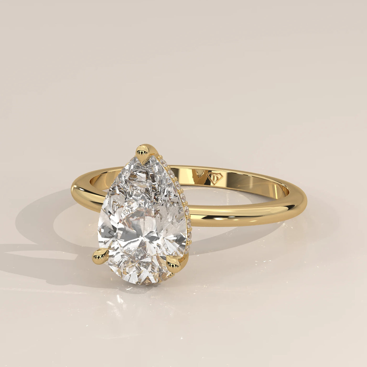 Yellow gold ring with a pear-cut diamond and pave band