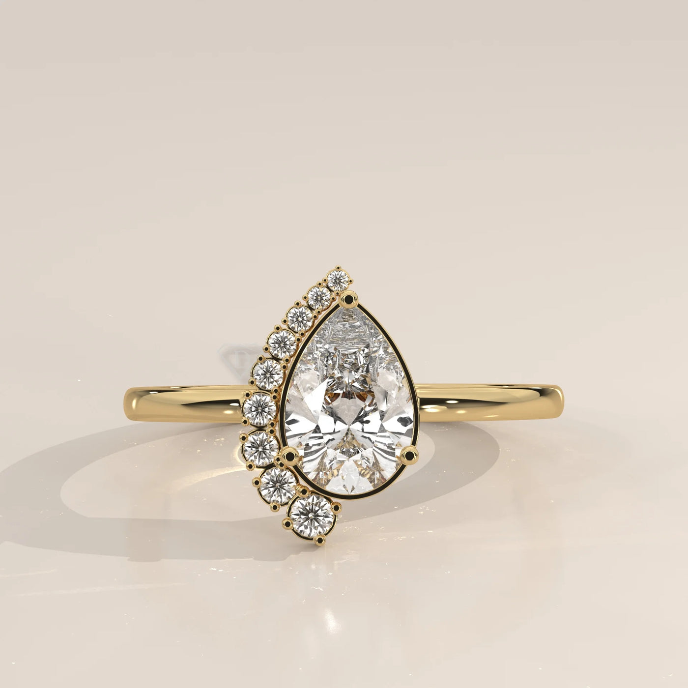 Yellow gold ring with a pear-shaped diamond and a cluster of small diamonds.