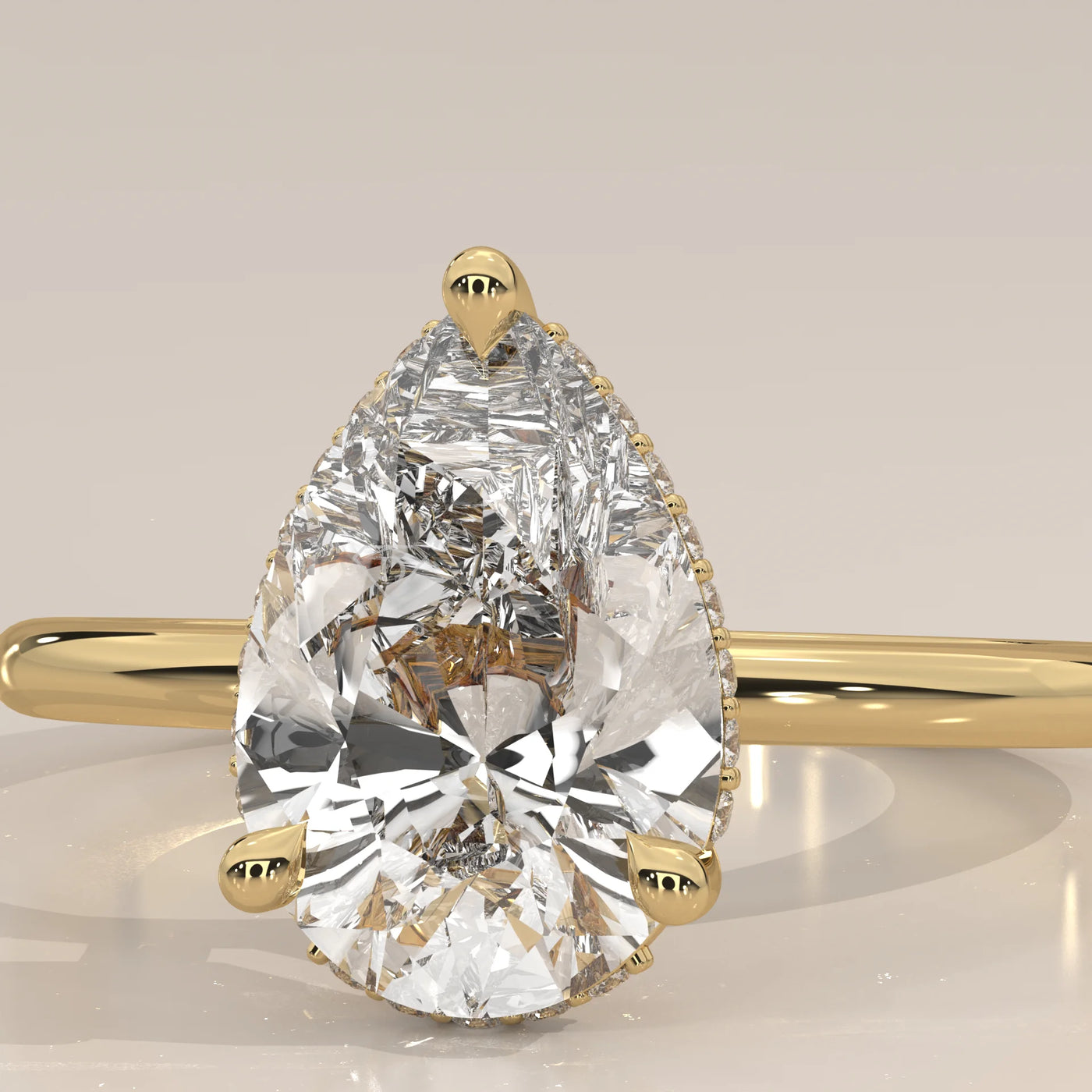 A pear-shaped diamond engagement ring with a 14k gold band.