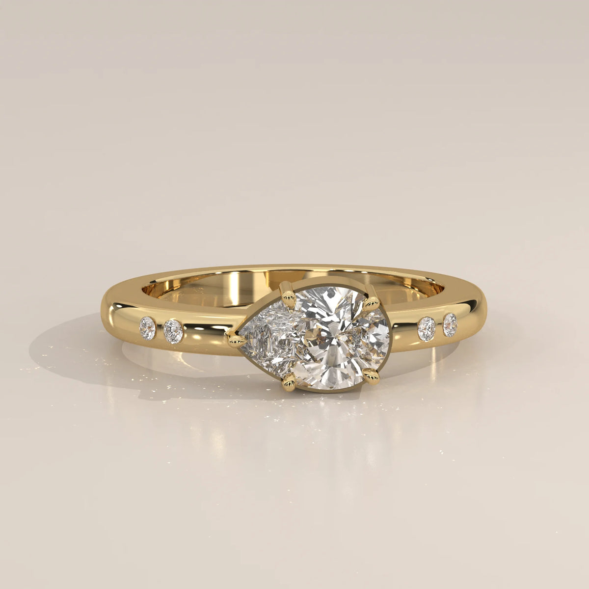 A 14k gold bypass ring with a pear-cut diamond.