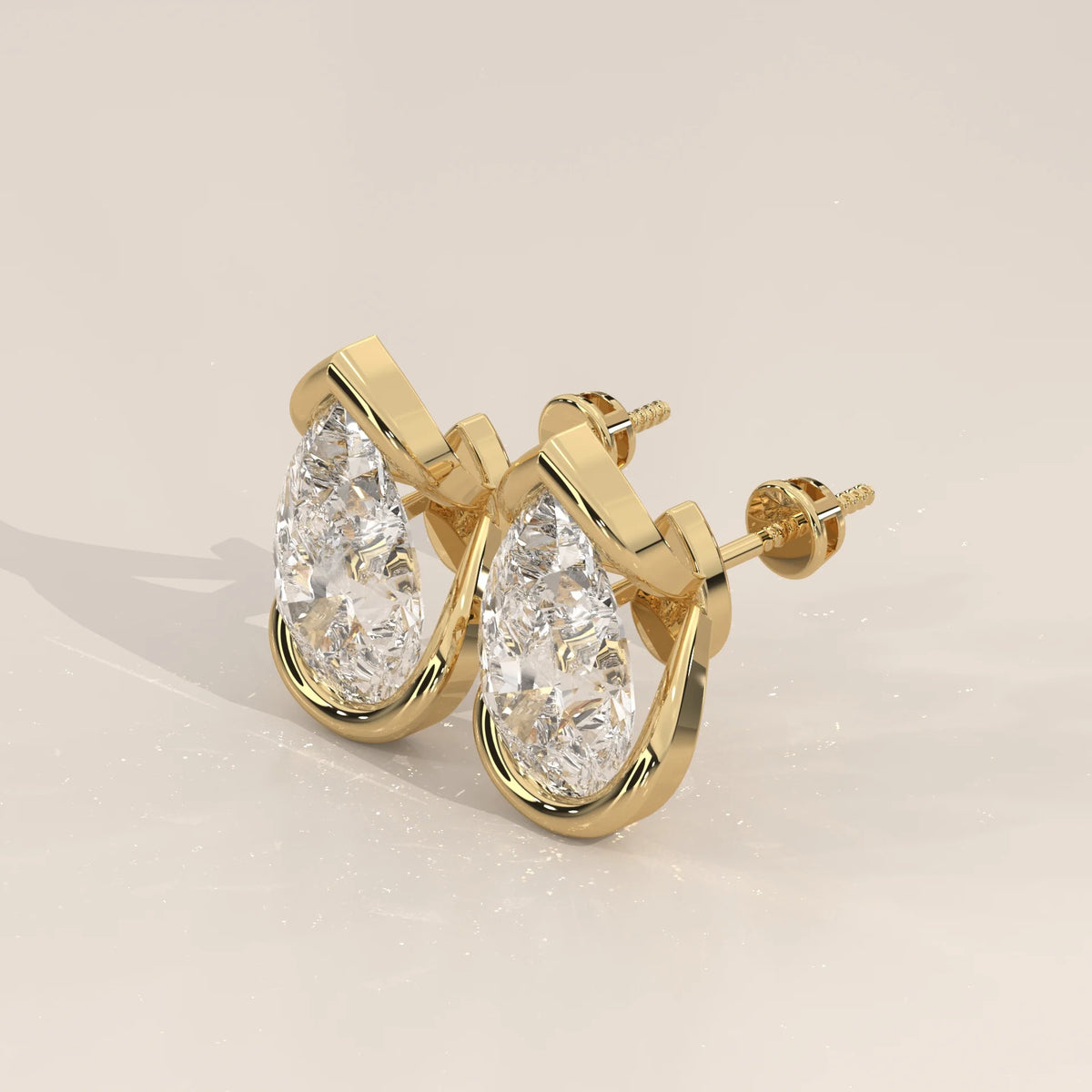 Pear Lab Grown Diamond Studs in a Curving Open Bezel in yellow gold, photographed head-on.
