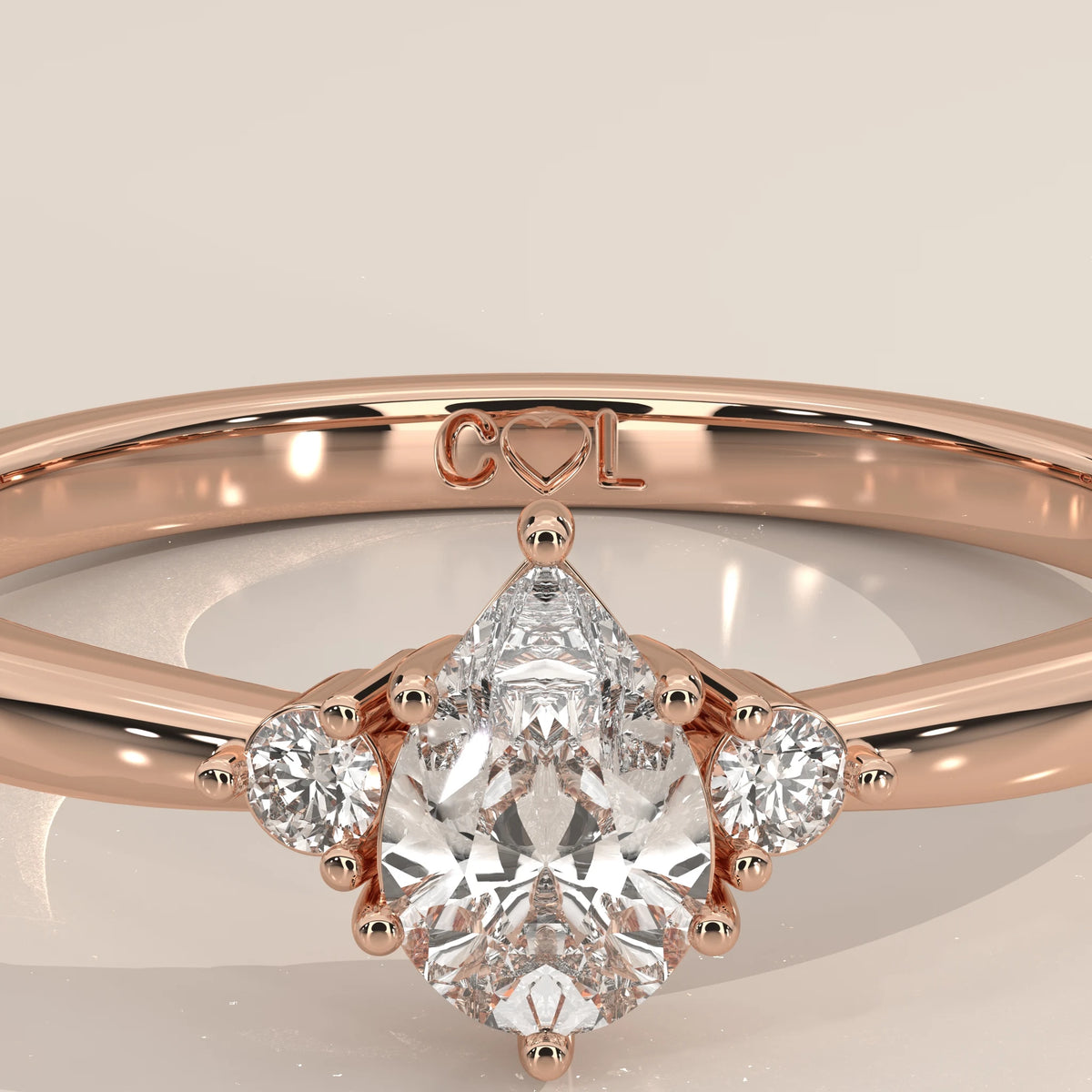 Pear lab grown diamond center stone in 14k rose gold claw prong setting, close-up