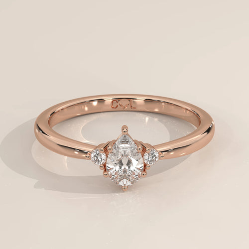 Pear lab grown diamond three stone engagement ring in 14k rose gold, three-quarter view