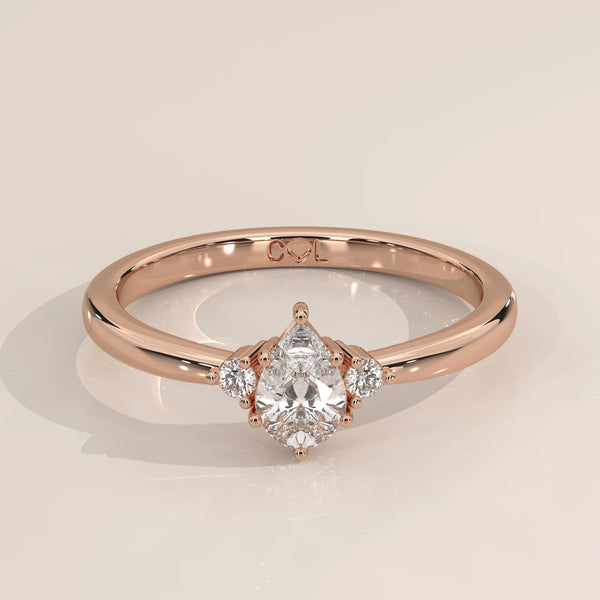 Pear lab grown diamond three stone engagement ring in 14k rose gold, three-quarter view