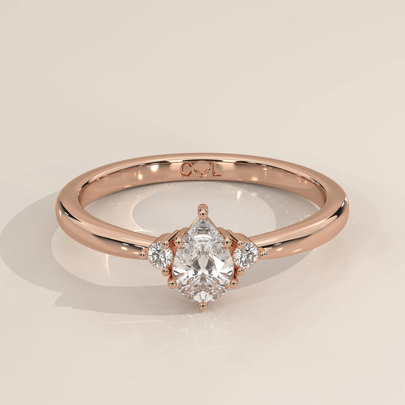 Pear lab grown diamond three stone engagement ring in 14k rose gold, three-quarter view
