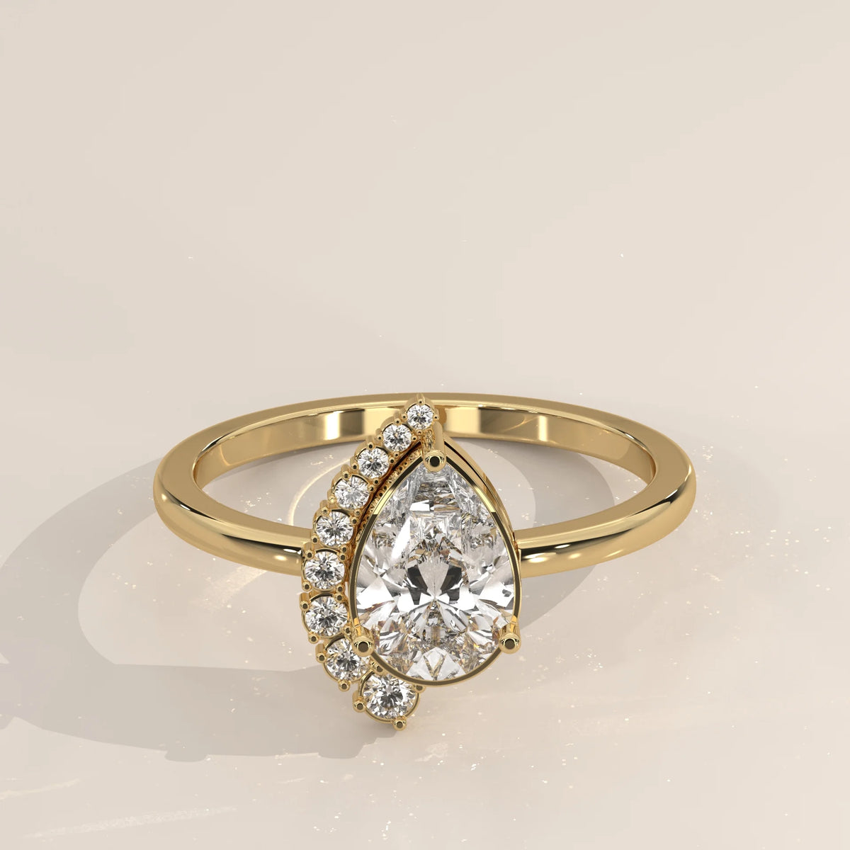A pear-shaped diamond ring with accent diamonds in gold.