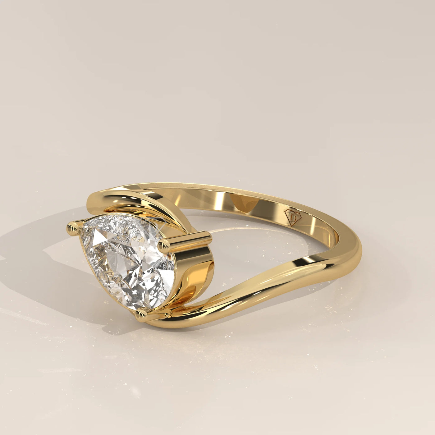 Yellow gold ring with a pear-shaped diamond and intricate band design.