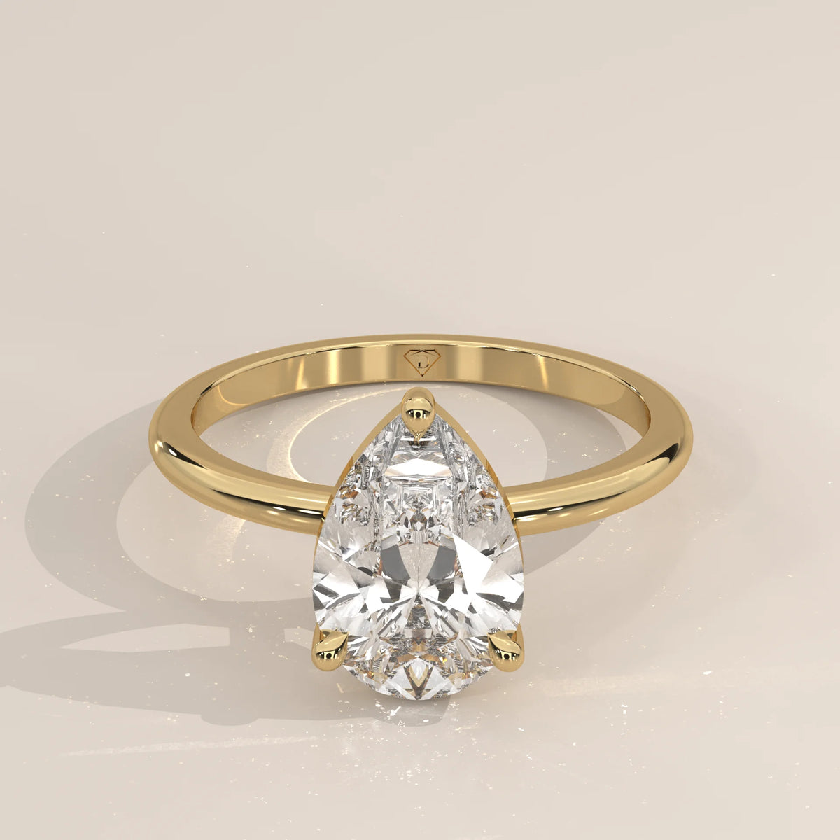 A classic solitaire engagement ring with a pear-shaped diamond in yellow gold.