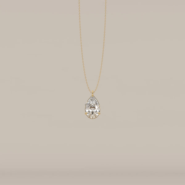 Gold pendant with a large, clear, teardrop-shaped faceted gemstone.