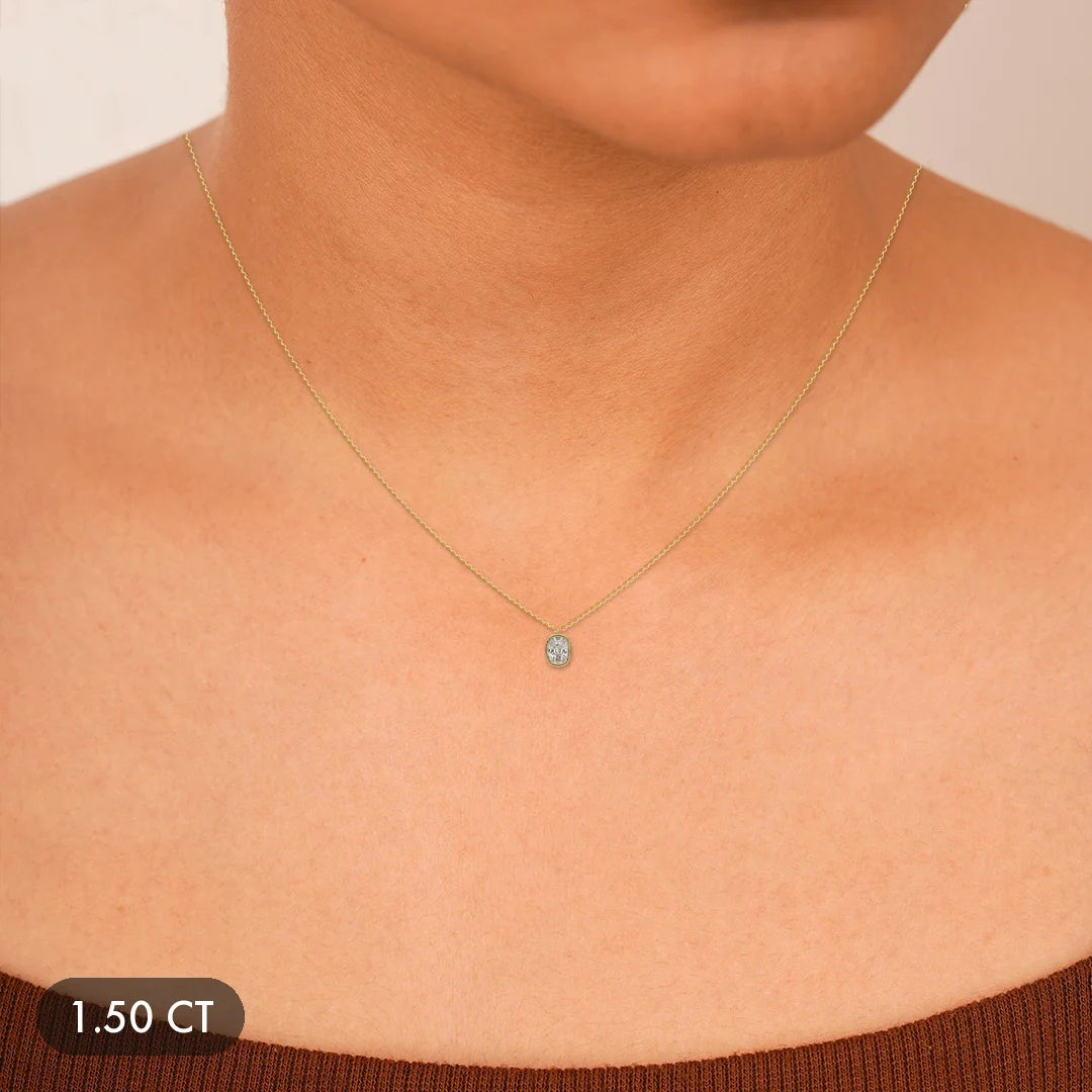 A delicate gold necklace with a small oval diamond pendant.