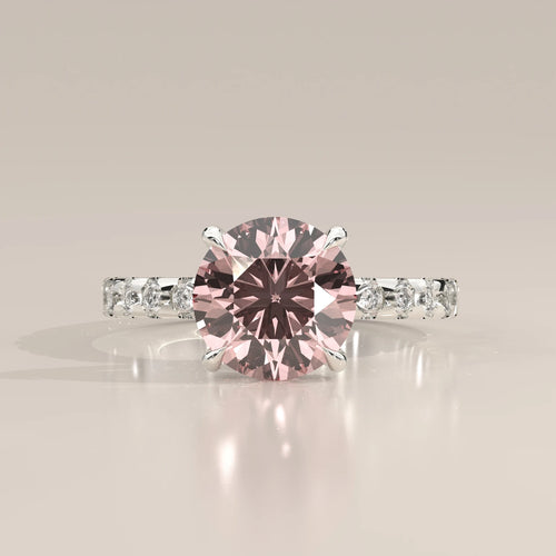 Front view of pink round lab grown diamond in four claw setting with white diamond band