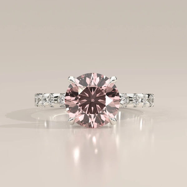 Front view of pink round lab grown diamond in four claw setting with white diamond band