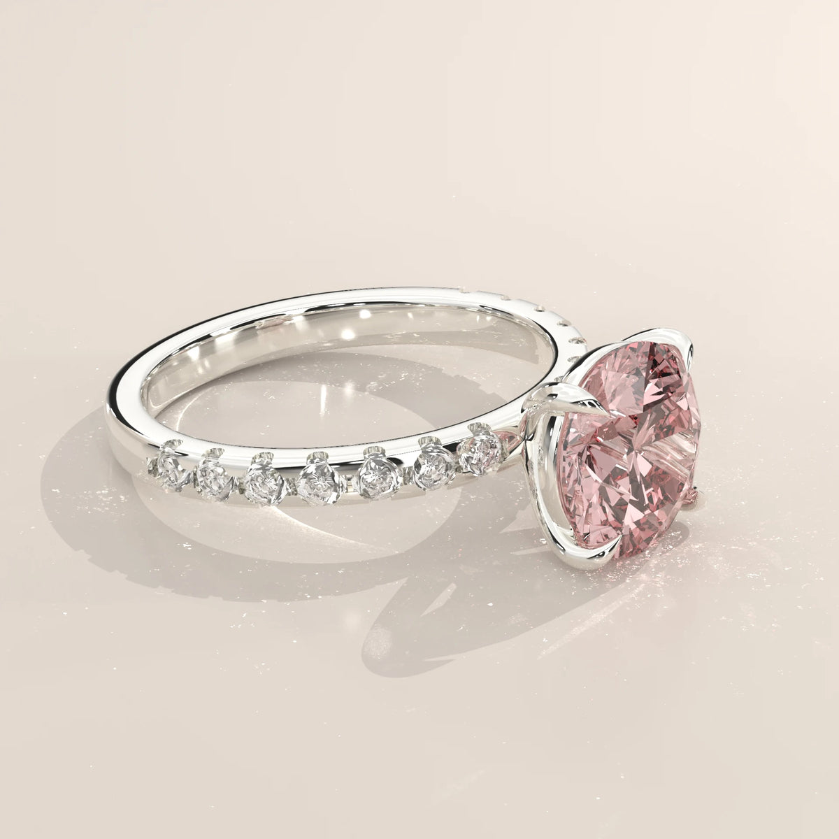 Pink round lab grown diamond engagement ring seen from the side at an angle