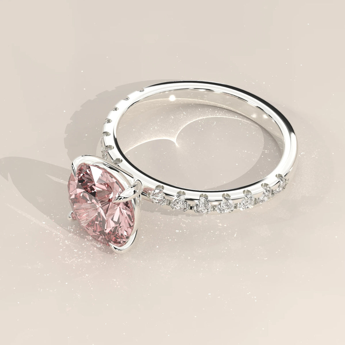 Tilted pink diamond engagement ring showing the pave set band