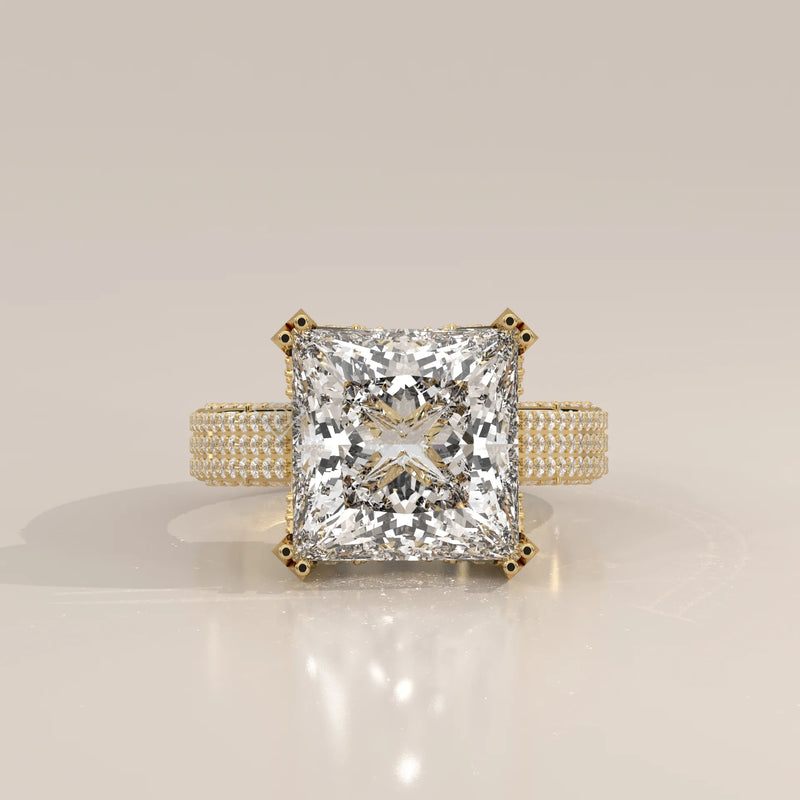 A stunning 14k yellow gold engagement ring with a large princess-cut diamond and pav

e-set side stones.