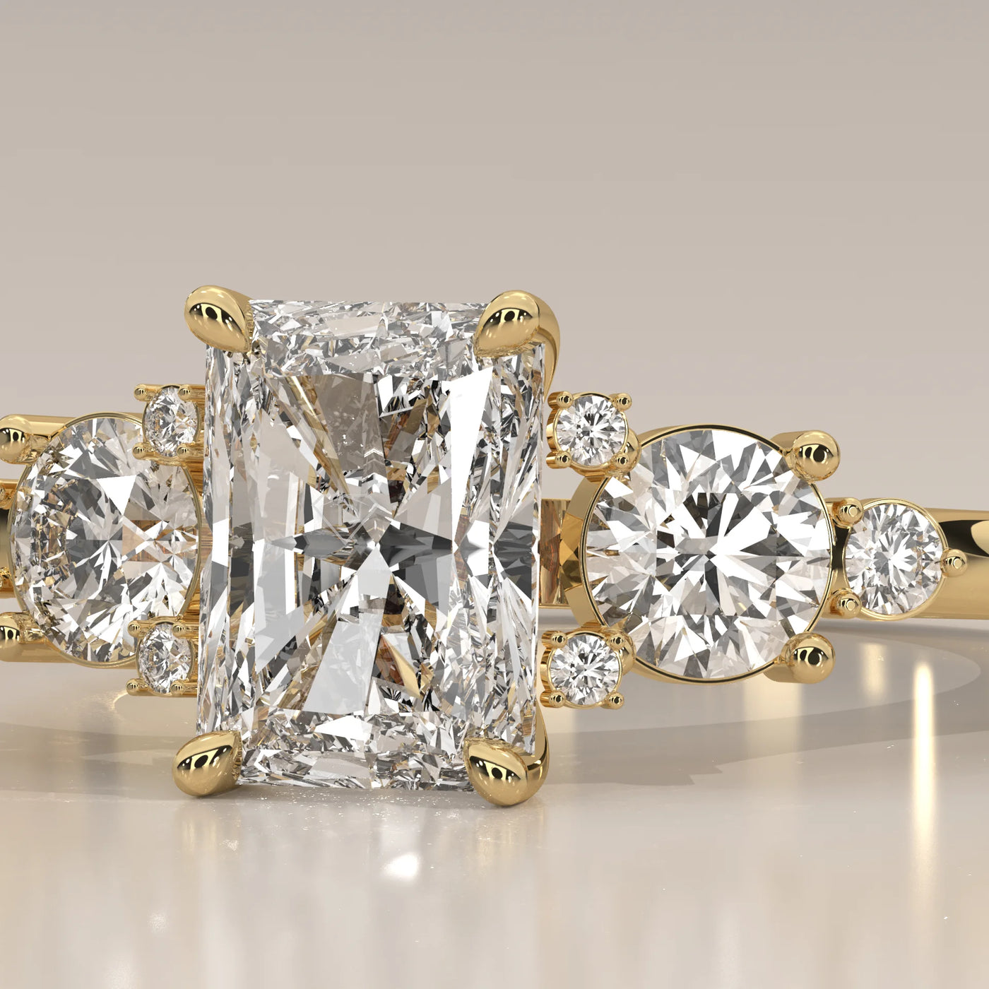 A radiant cut diamond ring with smaller accent stones in yellow gold.