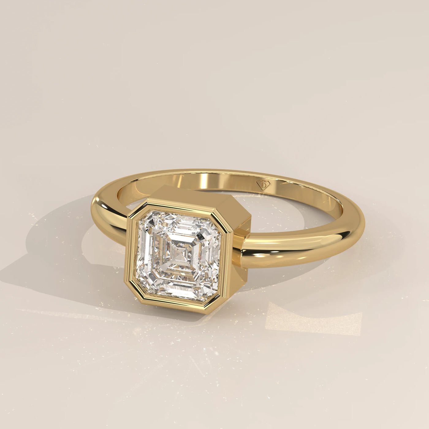Yellow gold ring featuring an asscher cut diamond in a bezel setting.