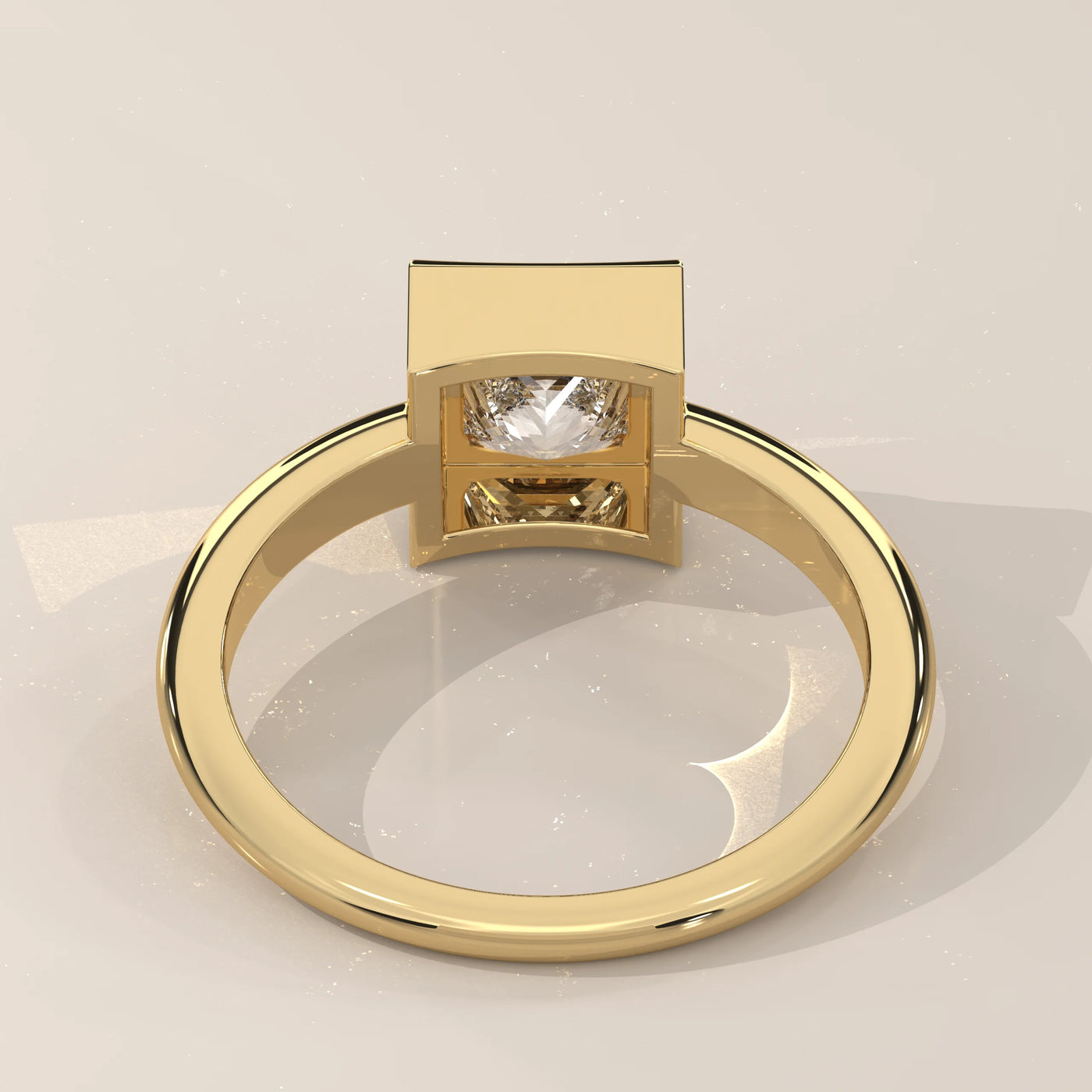 A yellow gold ring with a bezel-set diamond, shown from a slightly overhead angle.