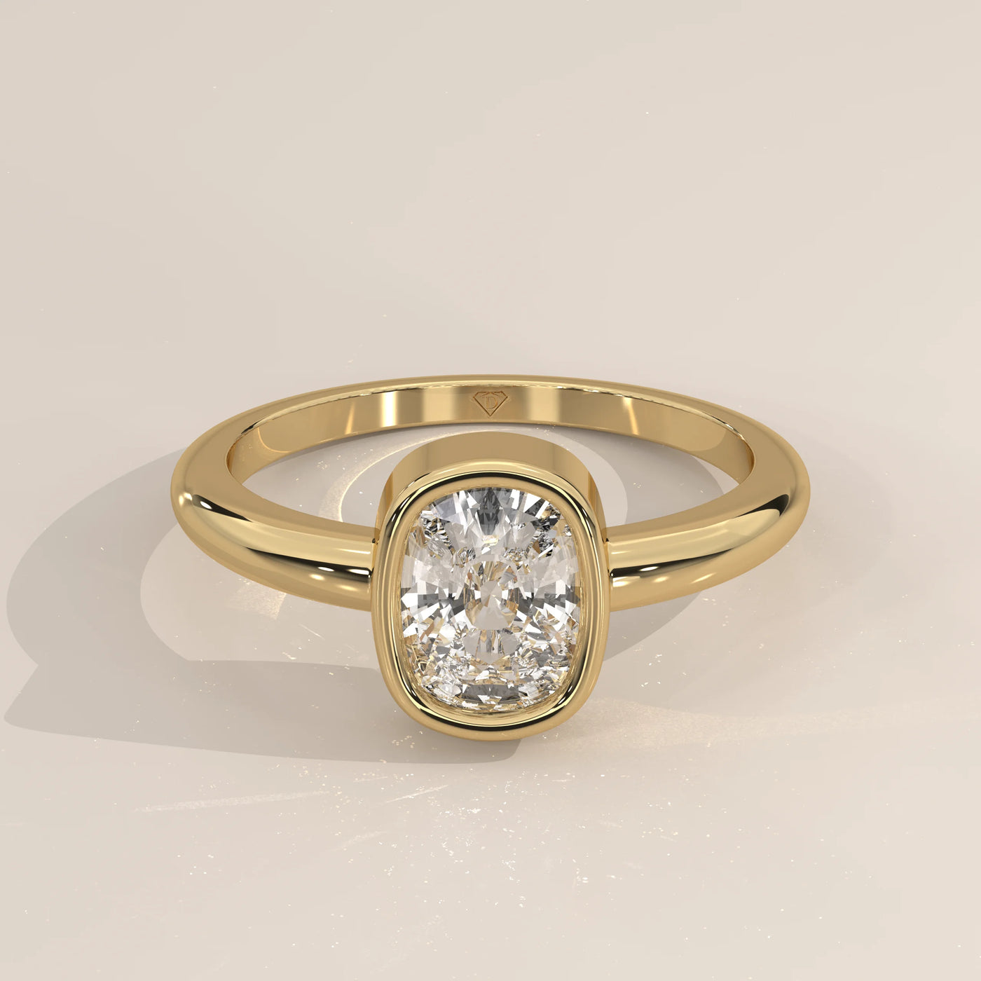 Gold ring with a cushion-cut diamond in a bezel setting.