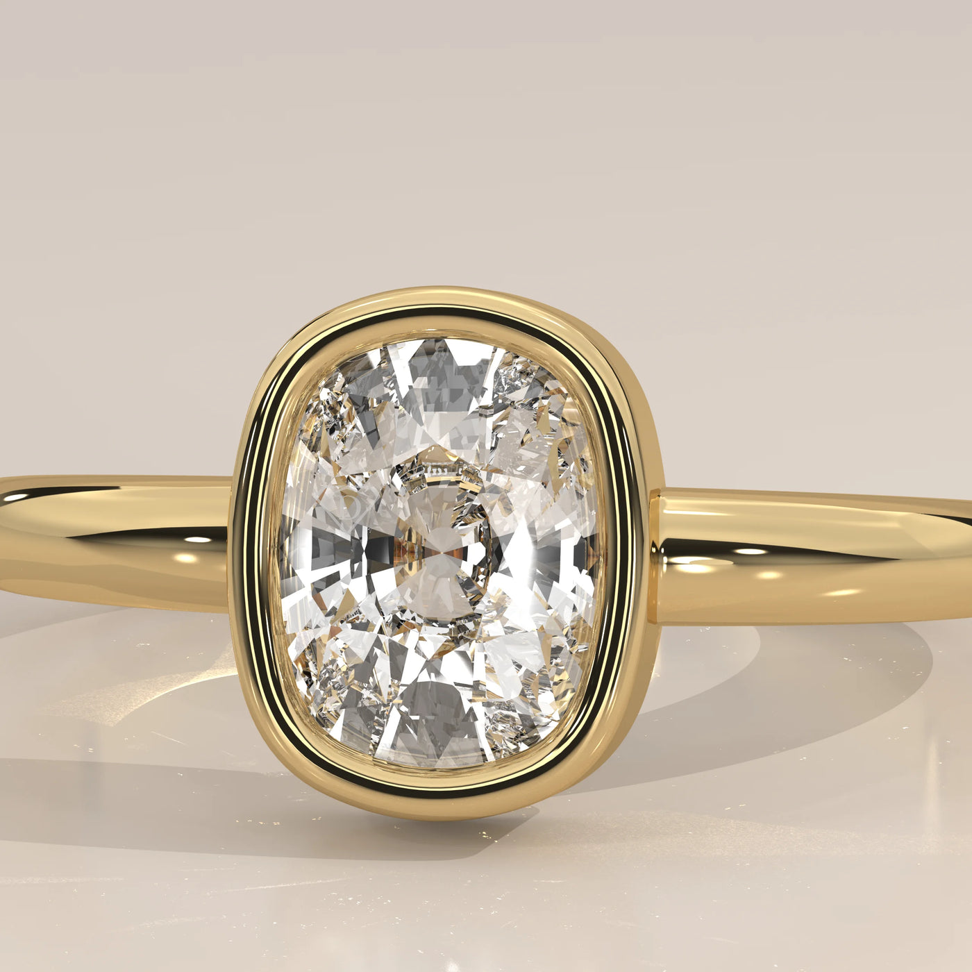 Gold ring with a large cushion-cut diamond in a bezel setting.