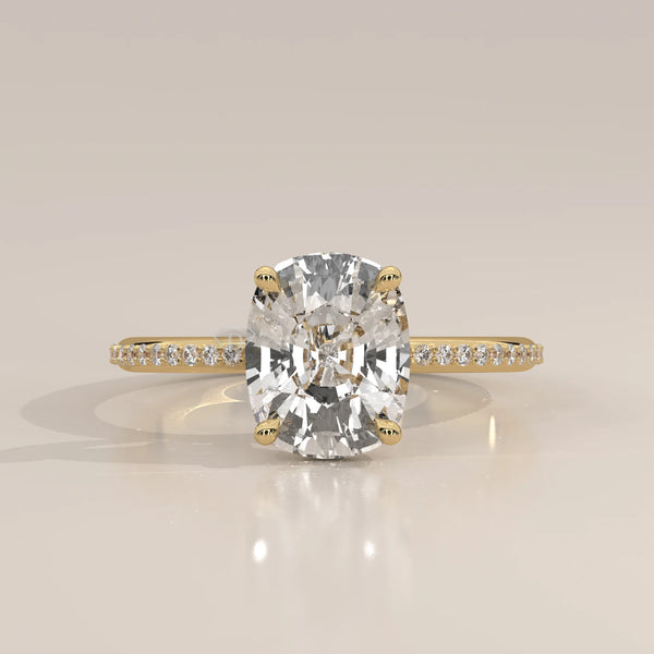 A cushion-cut diamond engagement ring in 14k yellow gold with pavé band.