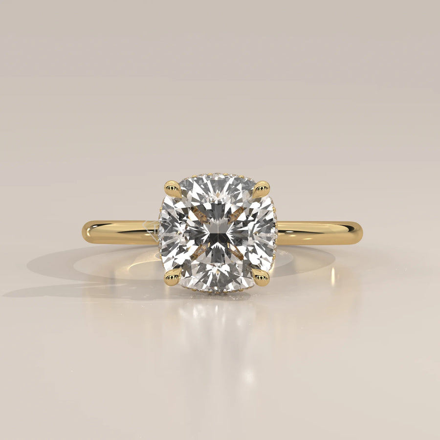 A cushion-cut diamond engagement ring in 14k yellow gold with pavé band.