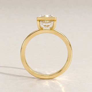 A 14k yellow gold ring with a cushion-cut diamond, side view.