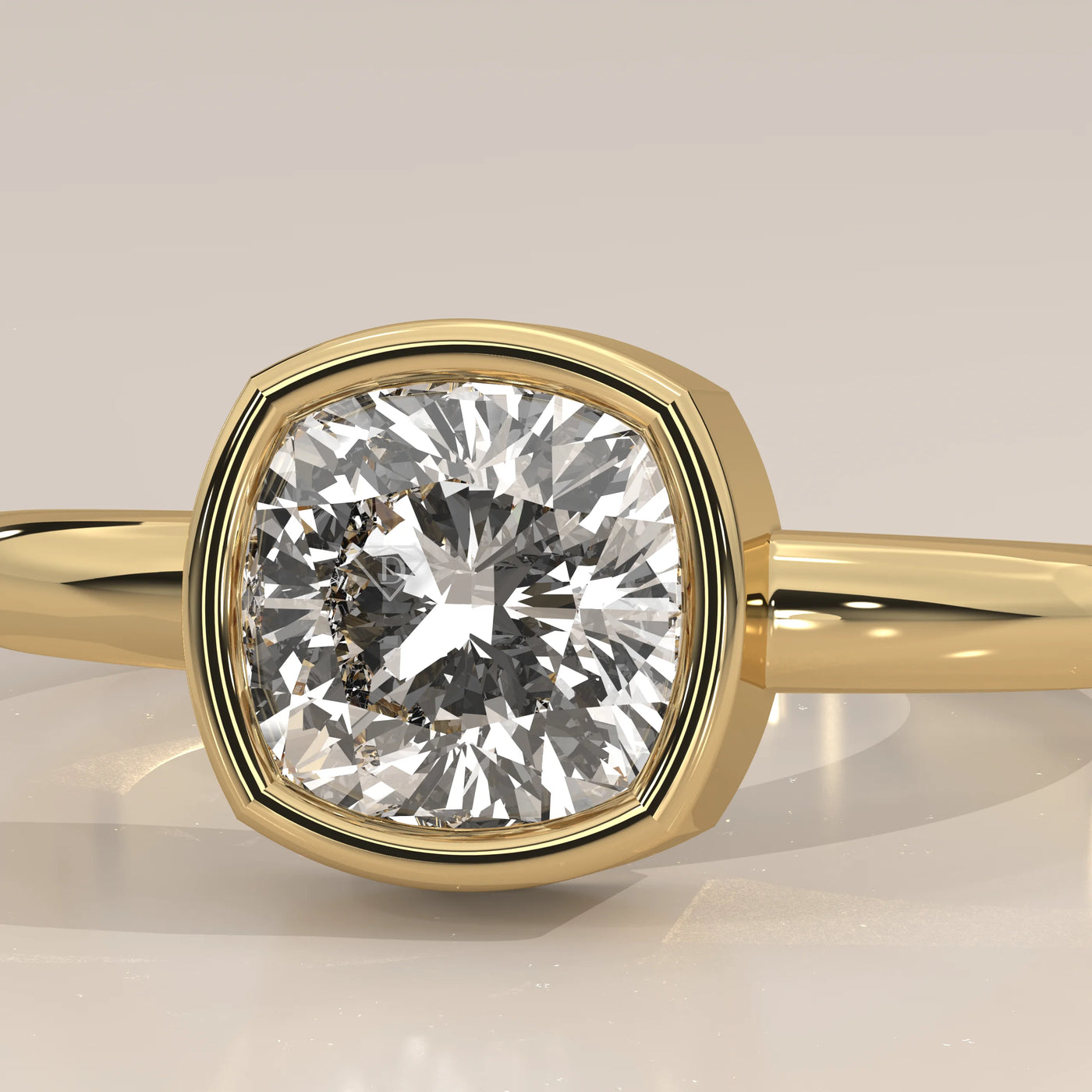A close-up view of a yellow gold ring with a cushion-cut diamond, bezel set.