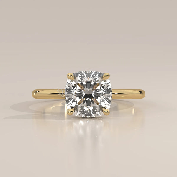 A solitaire cushion cut diamond ring in yellow gold with pav	acth band.