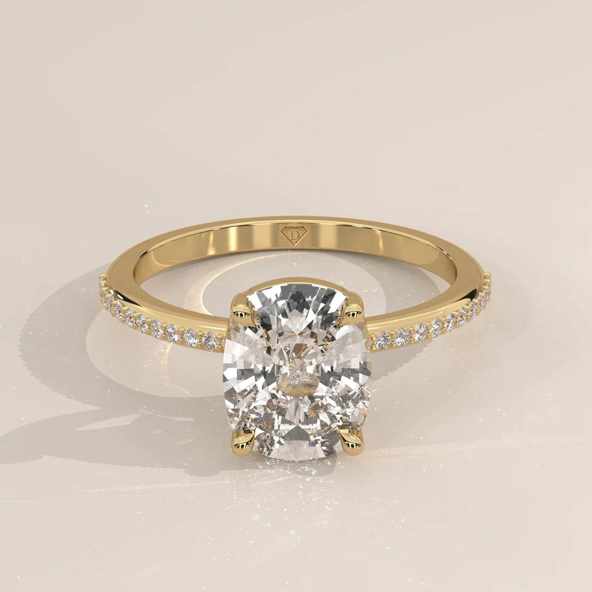 A solitaire cushion cut diamond ring in yellow gold with pav	acth band.