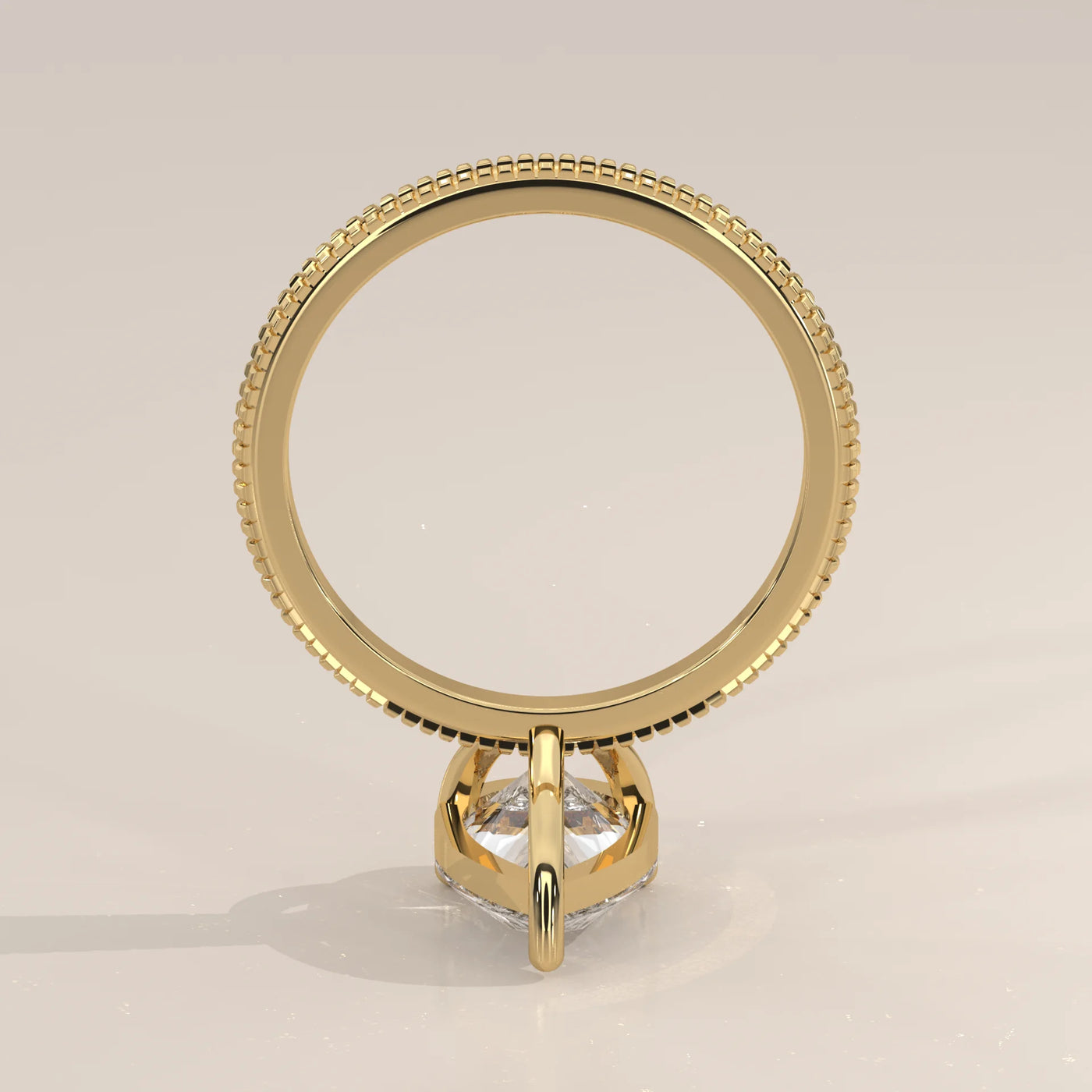 A yellow gold ring with a clear, prong-set gemstone, viewed from above.