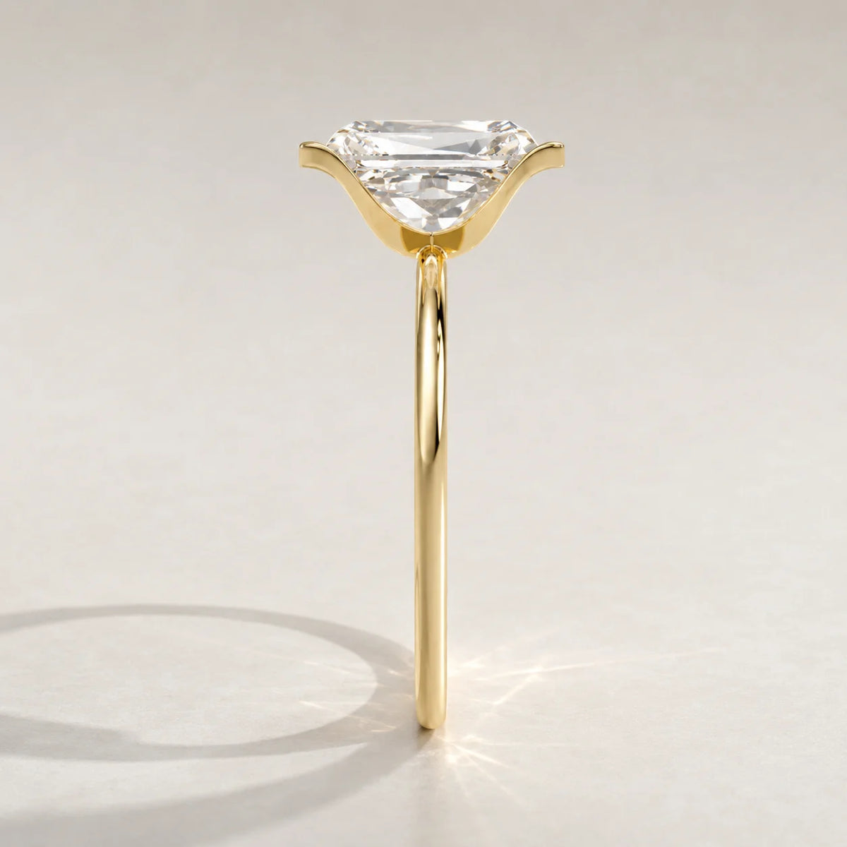 A yellow gold ring with an emerald-cut diamond set in a subtle claw setting.