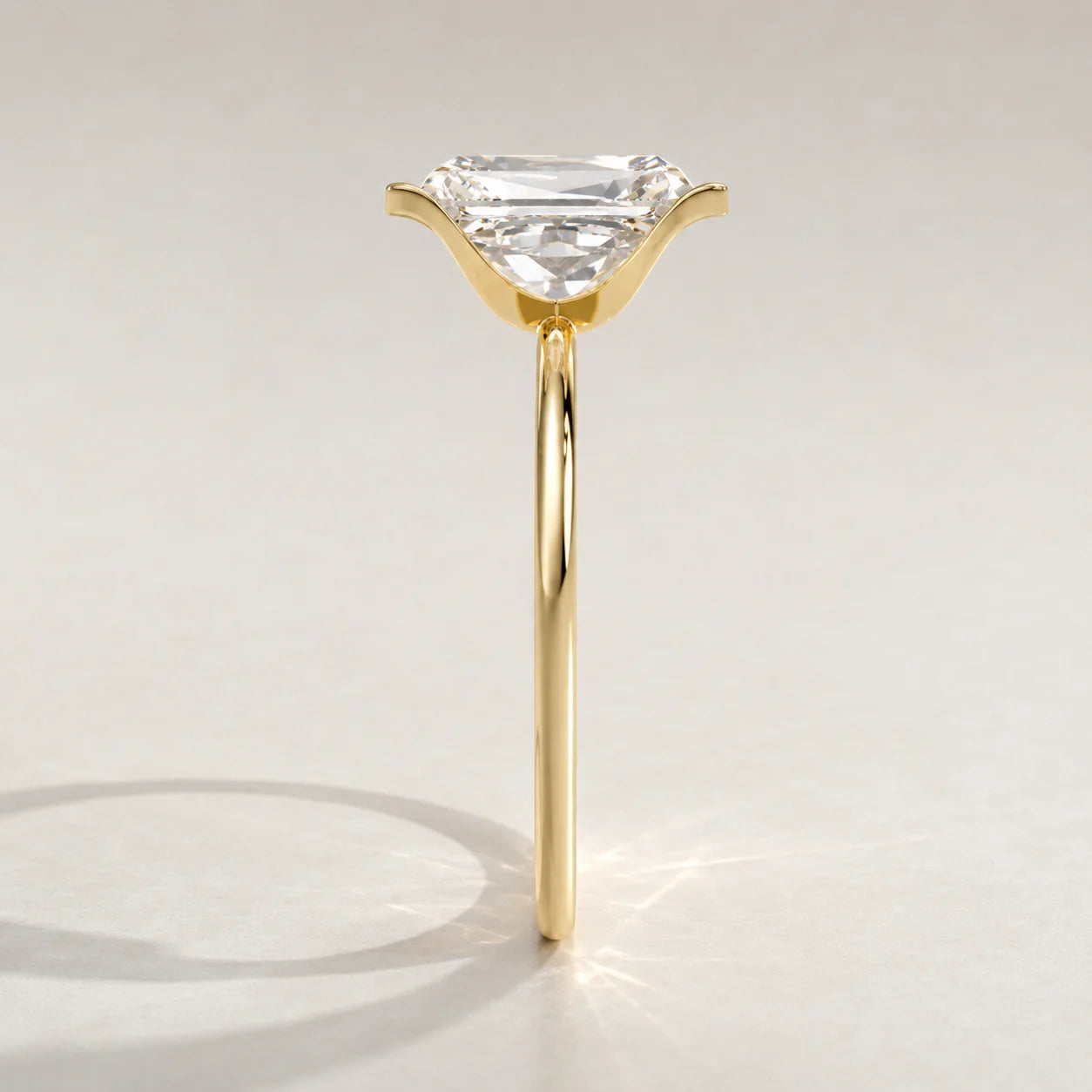 A yellow gold ring with an emerald-cut diamond set in a subtle claw setting.