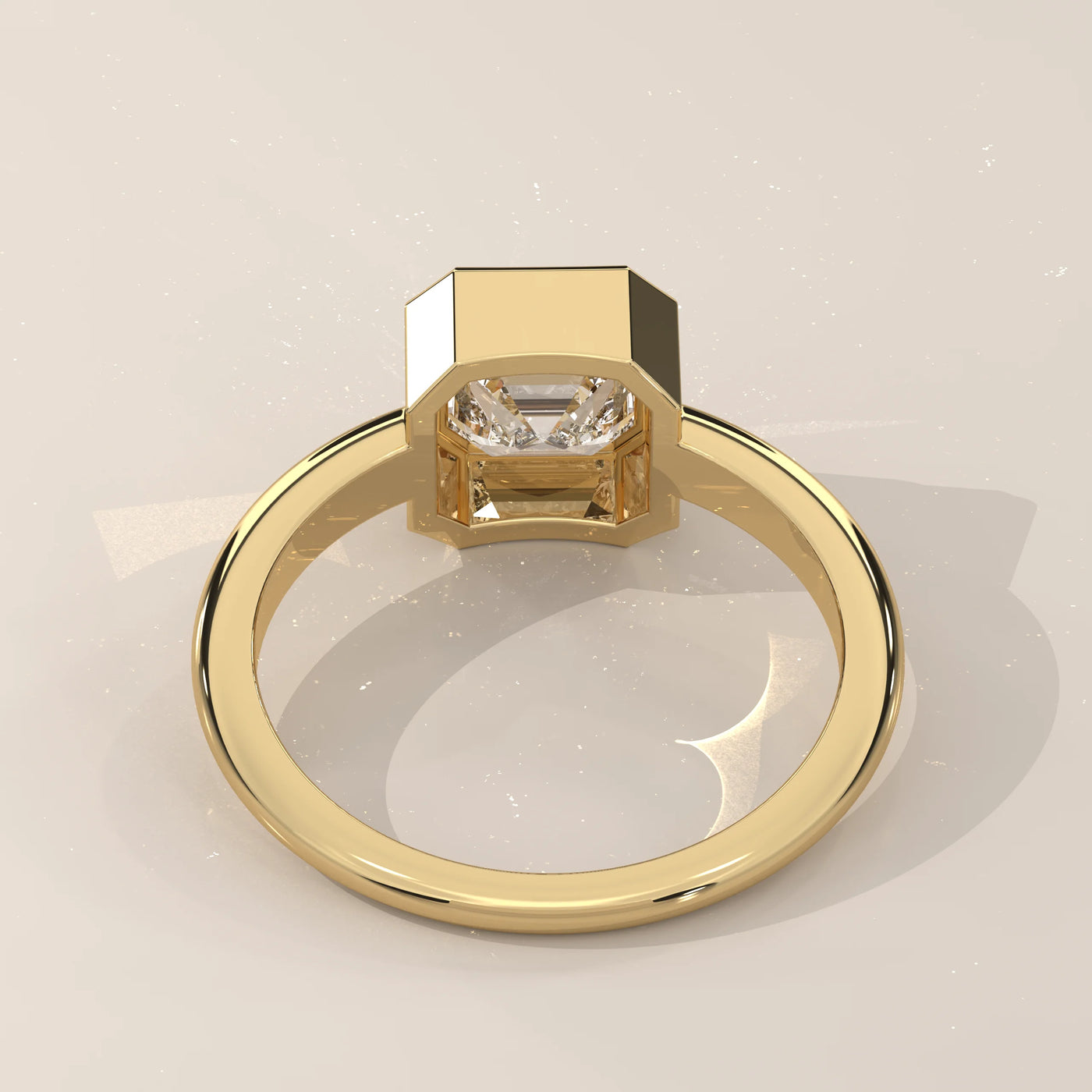 A yellow gold ring with a prominent emerald-cut diamond in a bezel setting, viewed from a back angle.