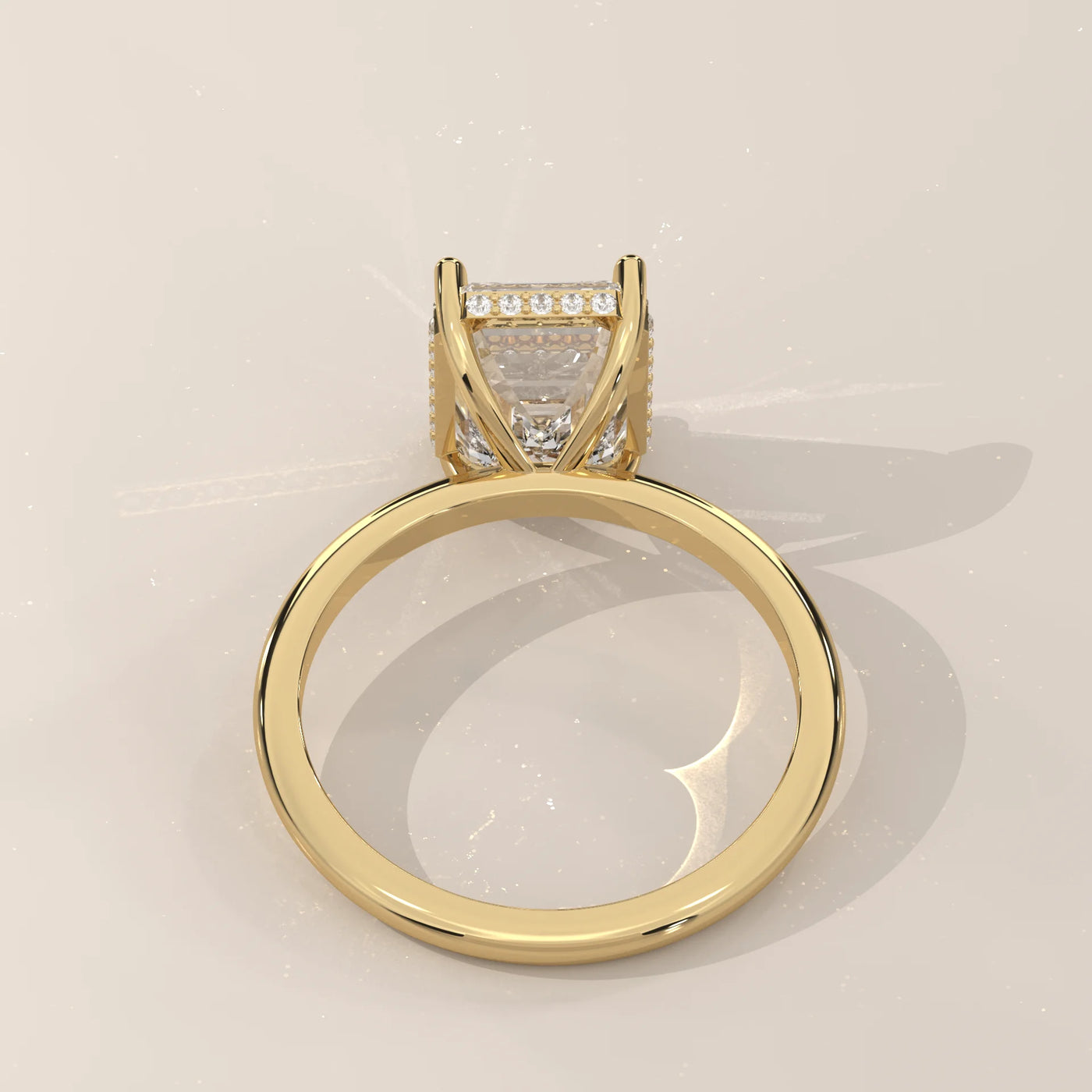 A yellow gold ring featuring a bezel-set emerald-cut diamond.